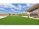 Expansive green lawn with a picturesque pond and seating areas provides a serene outdoor space at 2670 E Bellerive Dr, Gilbert, AZ 85298