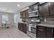 Updated kitchen features stainless steel appliances, granite countertops, tile backsplash and gray wood-look flooring at 2670 E Bellerive Dr, Gilbert, AZ 85298