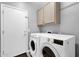 Laundry room featuring a washer, dryer, and overhead cabinets for storage at 2670 E Bellerive Dr, Gilbert, AZ 85298