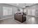 Bright living room features wood-look tile floors, high ceilings, ceiling fan, large windows and sliding doors to outside at 2670 E Bellerive Dr, Gilbert, AZ 85298