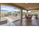 Covered back patio offering views of the landscaped yard with chairs and patio table at 26774 W Firehawk Dr, Buckeye, AZ 85396