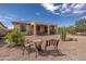 Exterior of home with covered patio, barbecue, desert landscaping and seating at 26774 W Firehawk Dr, Buckeye, AZ 85396