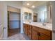 Modern bathroom featuring a double sink vanity, large mirror, and walk-in closet at 26774 W Firehawk Dr, Buckeye, AZ 85396