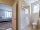 Bright bathroom featuring a glass shower, tile floors, and adjacent bedroom view at 26774 W Firehawk Dr, Buckeye, AZ 85396