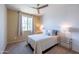 Inviting bedroom with large window, ceiling fan, and bedside tables at 26774 W Firehawk Dr, Buckeye, AZ 85396
