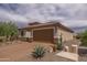 Charming exterior of a home with desert landscaping and a two-car garage on a sunny day at 26774 W Firehawk Dr, Buckeye, AZ 85396