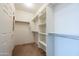 Well-organized walk-in closet with multiple shelves and hanging rods for ample storage space at 26774 W Firehawk Dr, Buckeye, AZ 85396