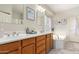 A bright main bathroom featuring dual sinks, a soaking tub, and natural light for a spa-like experience at 3059 E Parkview Dr, Gilbert, AZ 85295