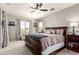 This is a bedroom boasting a large wooden bed, neutral tones, and bright windows with charming patterned curtains at 3059 E Parkview Dr, Gilbert, AZ 85295