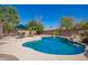 Backyard with a lagoon-style pool featuring an umbrella table and rock waterfall at 3059 E Parkview Dr, Gilbert, AZ 85295