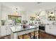 Stylish kitchen features white cabinets, marble countertops, stainless steel appliances, and a large island with seating at 4525 N 66Th St # 1, Scottsdale, AZ 85251