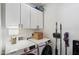 Functional laundry room with white cabinetry, washer, dryer, and storage accessories at 4525 N 66Th St # 1, Scottsdale, AZ 85251