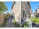 Corner view of backyard with brick pavers, potted plants, and a view of a two story home at 5439 W Odeum Ln, Phoenix, AZ 85043