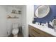 Updated half-bathroom features sleek fixtures and modern design with floating shelves for décor at 5439 W Odeum Ln, Phoenix, AZ 85043