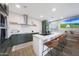 Modern kitchen featuring green cabinetry, stainless steel appliances, and a large marble-top island with seating at 5439 W Odeum Ln, Phoenix, AZ 85043
