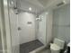 Updated bathroom with textured white tiles, glass-enclosed shower, and pebble flooring at 7120 E Kierland Blvd # 404, Scottsdale, AZ 85254