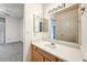 Bathroom featuring a large mirror, single sink vanity, and adjacent bedroom at 7575 E Indian Bend Rd # 1005, Scottsdale, AZ 85250