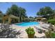 A community pool with lounge chairs and covered seating areas at 7575 E Indian Bend Rd # 1005, Scottsdale, AZ 85250