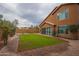 A home's well manicured backyard with a large grassy area and brick-paved walkway at 760 N Swallow Ln, Gilbert, AZ 85234