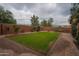 Spacious backyard with green lawn, brick paving, and mature trees, great for entertaining at 760 N Swallow Ln, Gilbert, AZ 85234