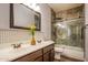 Bathroom featuring double sinks, decorative mirror, and tiled shower at 760 N Swallow Ln, Gilbert, AZ 85234