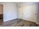 Neutral bedroom with grey walls, wood-look floors, and closet with sliding doors at 760 N Swallow Ln, Gilbert, AZ 85234
