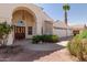 Attractive home showcasing a covered entryway, desert landscaping, a three-car garage, and a palm tree at 804 N 46Th St, Mesa, AZ 85205