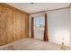 This bedroom features wood paneling and a window, providing a cozy and inviting space at 8103 E Southern Ave # 69, Mesa, AZ 85209