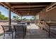 Covered back patio with outdoor dining area, grill, and access to the backyard at 8415 W Coolidge St, Phoenix, AZ 85037