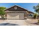 Exterior shot showcasing a two-car garage with decorative windows and a well-maintained driveway with desert landscaping at 8415 W Coolidge St, Phoenix, AZ 85037