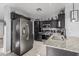 Modern kitchen with stainless steel appliances, granite countertops, and dark cabinets, offering a sleek and functional space at 8415 W Coolidge St, Phoenix, AZ 85037