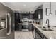 Well-equipped kitchen with stainless steel appliances, dark cabinetry, and granite countertops at 8415 W Coolidge St, Phoenix, AZ 85037