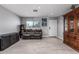 Neutral living room features tile floors, a window, a gray couch, and a traditional wood cabinet at 8415 W Coolidge St, Phoenix, AZ 85037