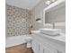 Stylish bathroom showcasing quartz counters and decorative tile surrounding tub and shower at 1051 S Dobson Rd # 67, Mesa, AZ 85202