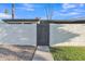 Charming enclosed front entrance with gray gate and stucco facade surrounded by rocks and green grass at 1051 S Dobson Rd # 67, Mesa, AZ 85202