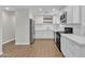 Renovated kitchen featuring white cabinets, quartz countertops, stainless steel appliances, and wood-look tile flooring at 1051 S Dobson Rd # 67, Mesa, AZ 85202