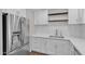Upgraded kitchen showcasing stainless steel refrigerator, white cabinets, quartz countertops, and wood shelving at 1051 S Dobson Rd # 67, Mesa, AZ 85202