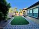 Private backyard featuring a lush lawn, paved patio, and verdant plants at 10538 E Naranja Ave, Mesa, AZ 85209