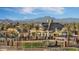 Aerial view of community clubhouse, pool, barbecue area, and nearby mountain at 10538 E Naranja Ave, Mesa, AZ 85209