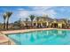 Community swimming pool with palm trees and clubhouse in the background at 10538 E Naranja Ave, Mesa, AZ 85209