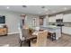 Open-concept dining area with a wooden table, wicker chairs, and seamless flow to the modern kitchen at 10556 W Bloch Rd, Tolleson, AZ 85353