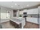 Modern kitchen featuring white cabinets, stainless steel appliances, and a granite-topped island with bar seating at 10556 W Bloch Rd, Tolleson, AZ 85353