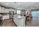 Open-concept kitchen with white cabinets, stainless steel appliances, and granite countertops flowing into the living room at 10556 W Bloch Rd, Tolleson, AZ 85353