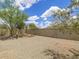 View of the spacious backyard with gravel landscaping, block fence, and mature trees at 10613 S 41St Pl, Phoenix, AZ 85044