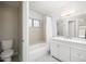 This renovated bathroom boasts a shower over tub, white vanity and modern lighting at 10613 S 41St Pl, Phoenix, AZ 85044