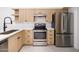Updated kitchen featuring stainless steel appliances, light wood cabinets, and elegant countertops at 10613 S 41St Pl, Phoenix, AZ 85044