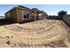 Spacious backyard with dirt, a partial roof covering, and a framed structure of a new home at 11410 E Utah Ave, Mesa, AZ 85212