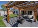 Outdoor oasis featuring a pergola, a fire pit, patio furniture, lush turf, and a BBQ grill for ultimate relaxation at 11601 W Bloomfield Rd, El Mirage, AZ 85335