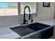 Close up of a deep kitchen sink featuring modern faucet fixtures and bright countertops at 12234 S Pewaukee St, Phoenix, AZ 85044