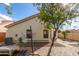 Paver patio leads around the side of this tan house under a clear blue sky at 13864 W Ironwood St, Surprise, AZ 85374